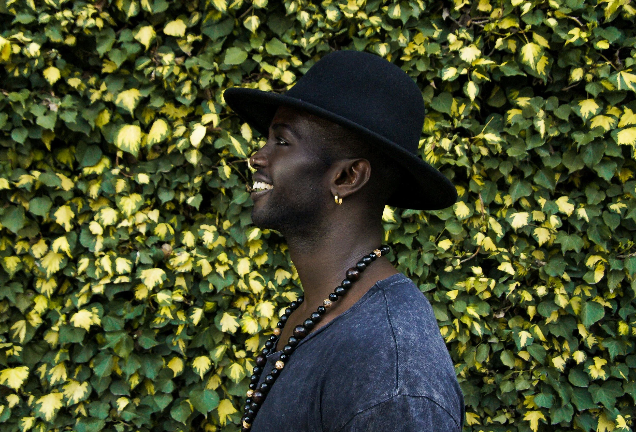 Profile photo of a handsome African American male with a hat looking to the right towards the text explaining our hair removal pricing.